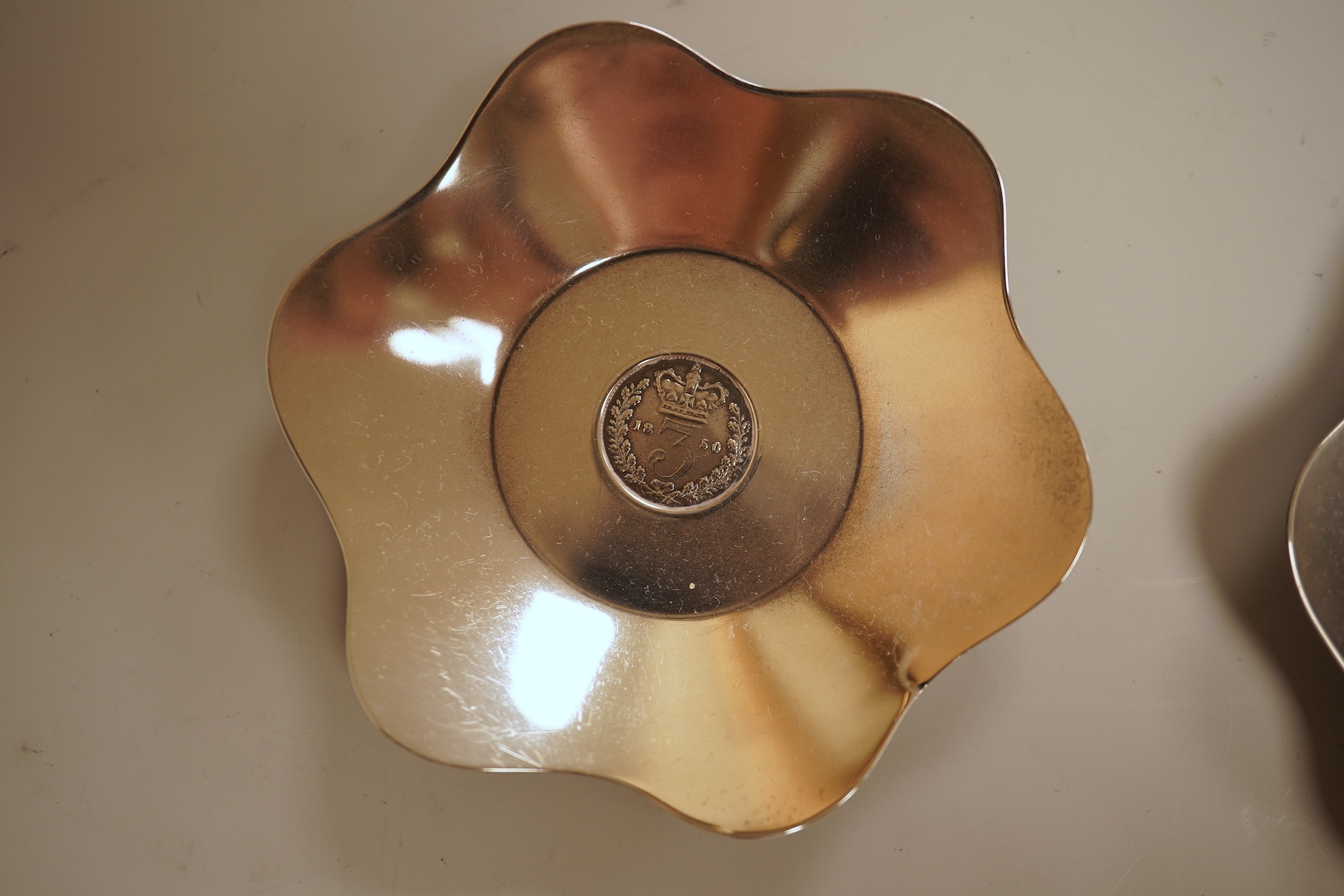 A cased set of four George V silver flower head shaped nut dishes, each inset with an 1850 maundy coin, Walker & Hall, Birmingham, 1936, diameter 77mm.